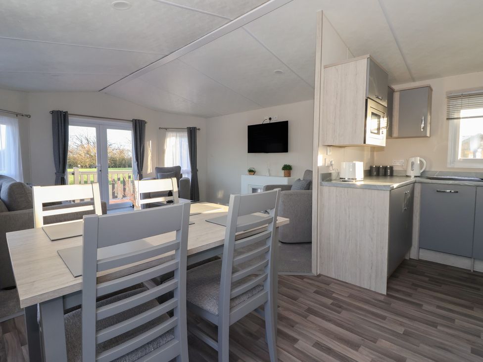 A living room with a dining table and kitchen area at Meadows Park 4 Great Hatfield near Hornsea