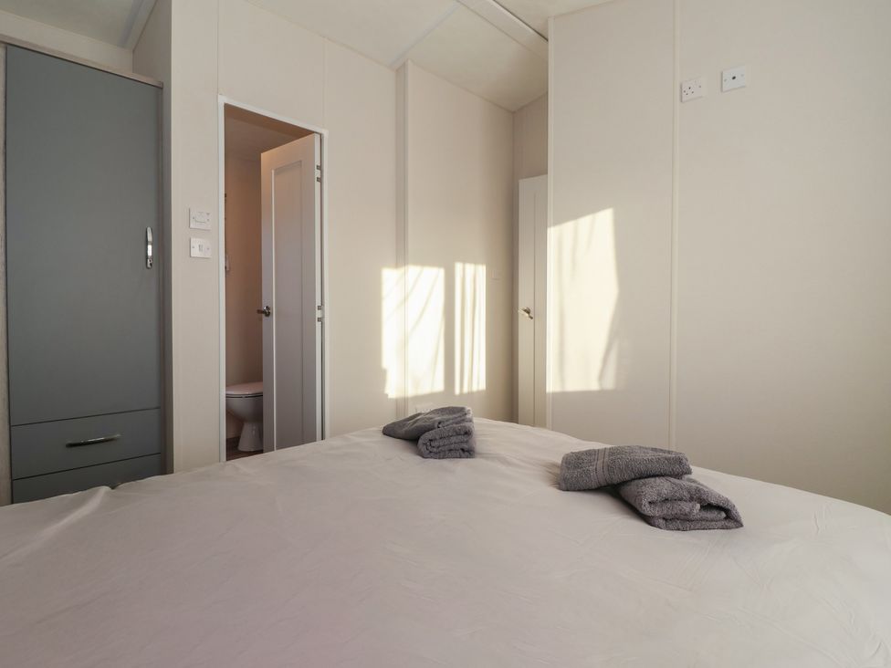 A bedroom with a bed and towels on it at Meadows Park 4 near Hornsea