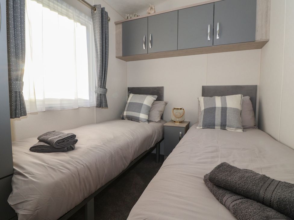 A bedroom with two beds and a nightstand at Meadows Park 4 Great Hatfield near Hornsea
