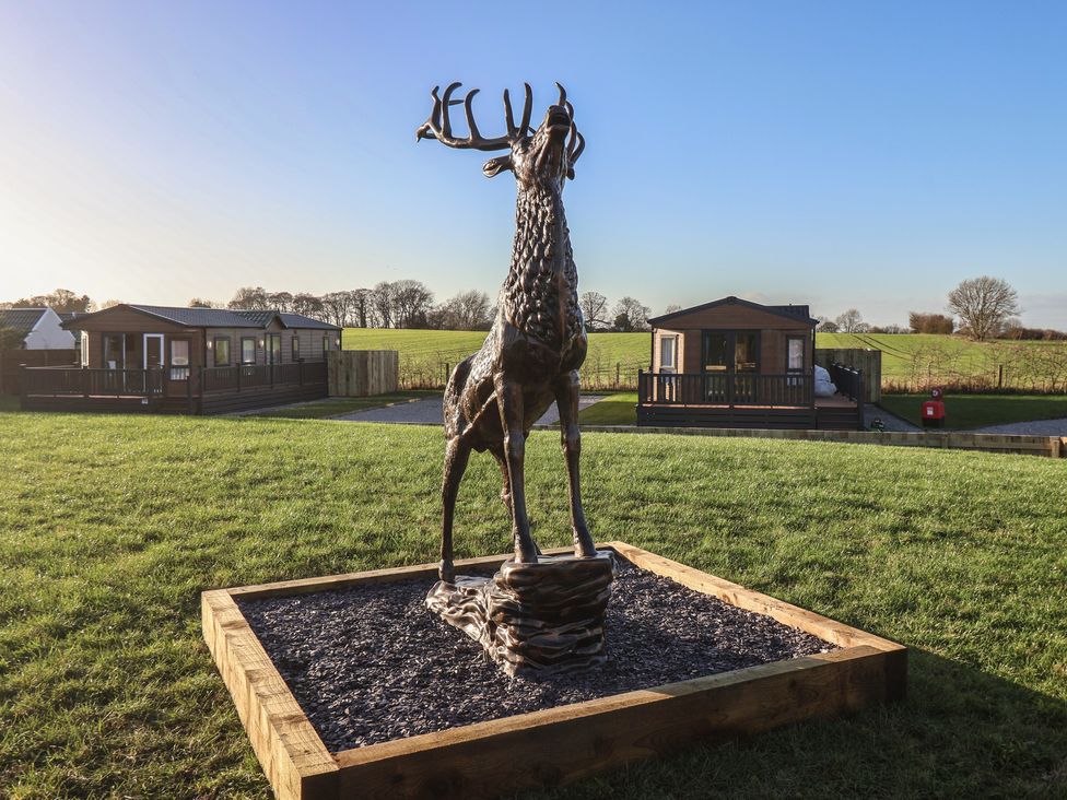 A deer statue with lodges in the background at Meadows Park 4 Great Hatfield near Hornsea