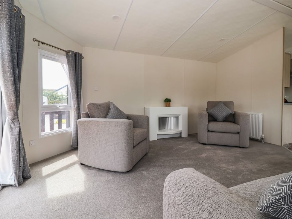 A living room with armchairs and a fireplace at Meadows Park 5 near Great Hatfield