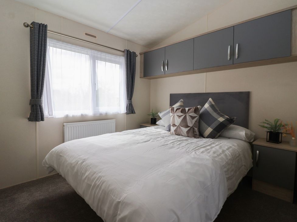 A bedroom with a bed and storage cabinets at Meadows Park 5 Great Hatfield near Hornsea