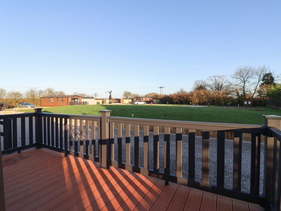 A view from a deck showing grass and cars at Meadows Park 5 Great Hatfield near Hornsea