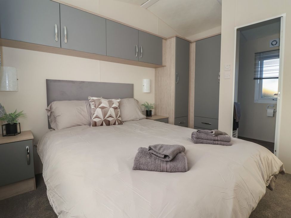 A bedroom with a bed and cupboards at Meadows Park 5 Great Hatfield near Hornsea