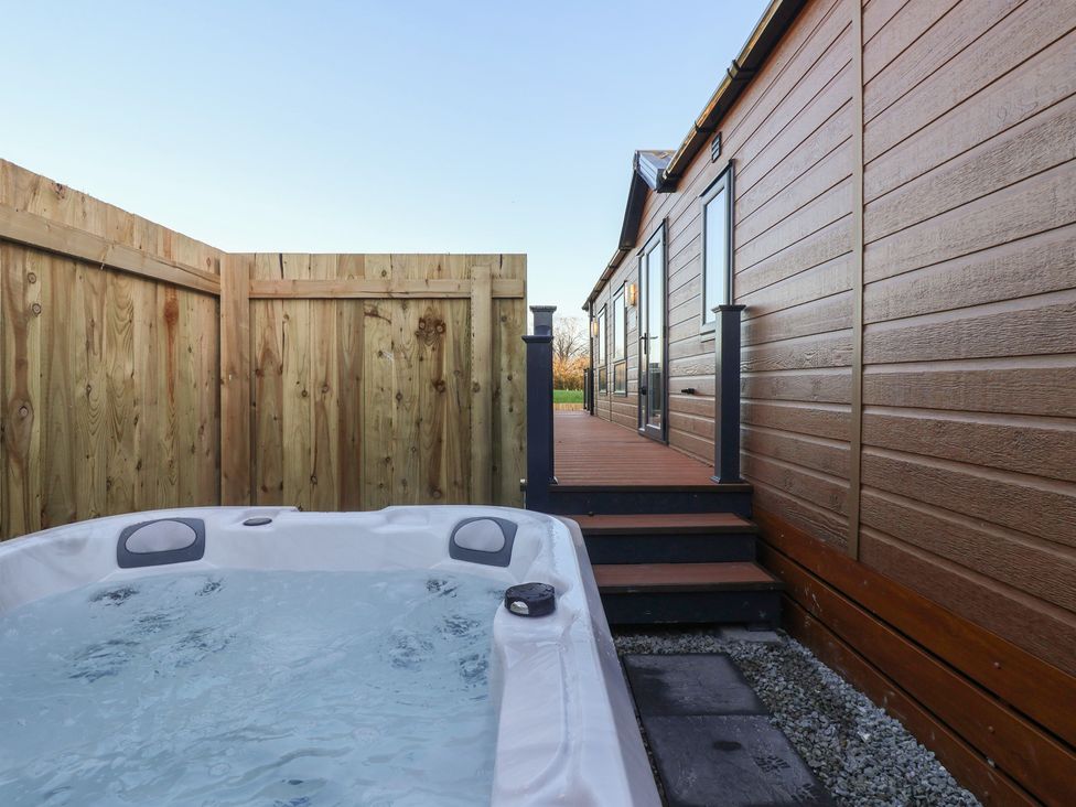 An outdoor area with a hot tub and wooden fencing at Meadows Park 5 Great Hatfield near Hornsea