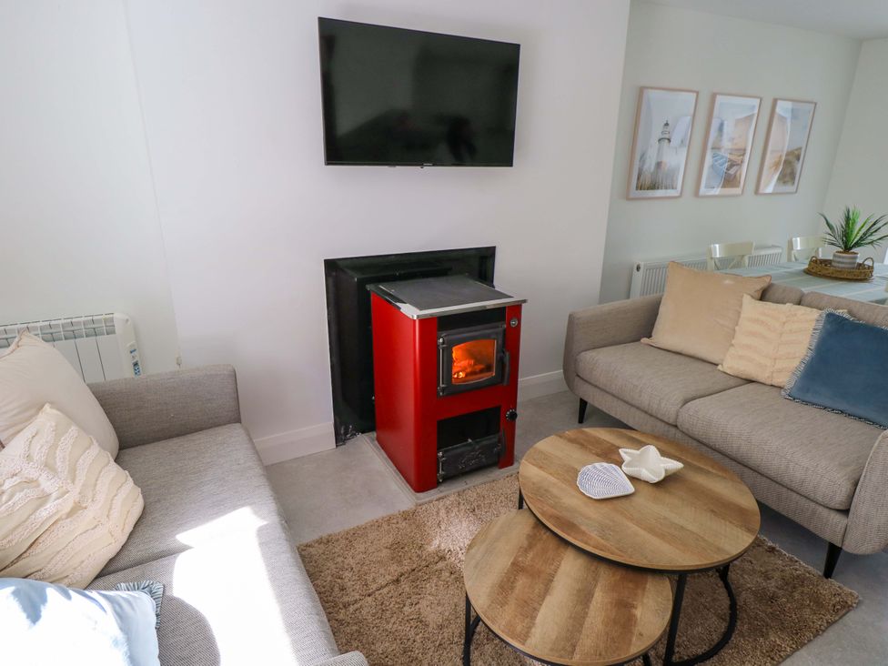 A living room with a stove and sofa at Rose Cottage, Killala, County Mayo