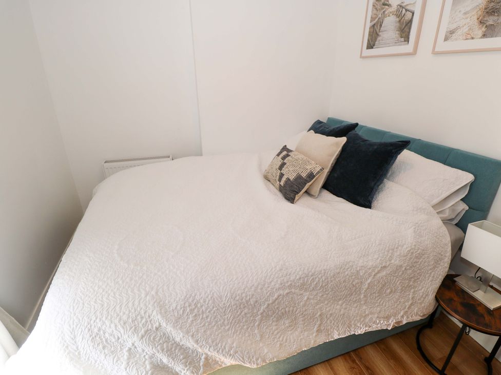 A bedroom with a bed and side table at Rose Cottage, Killala, County Mayo