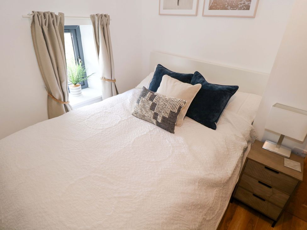 A bedroom with a bed and pillows at Rose Cottage, Killala, County Mayo