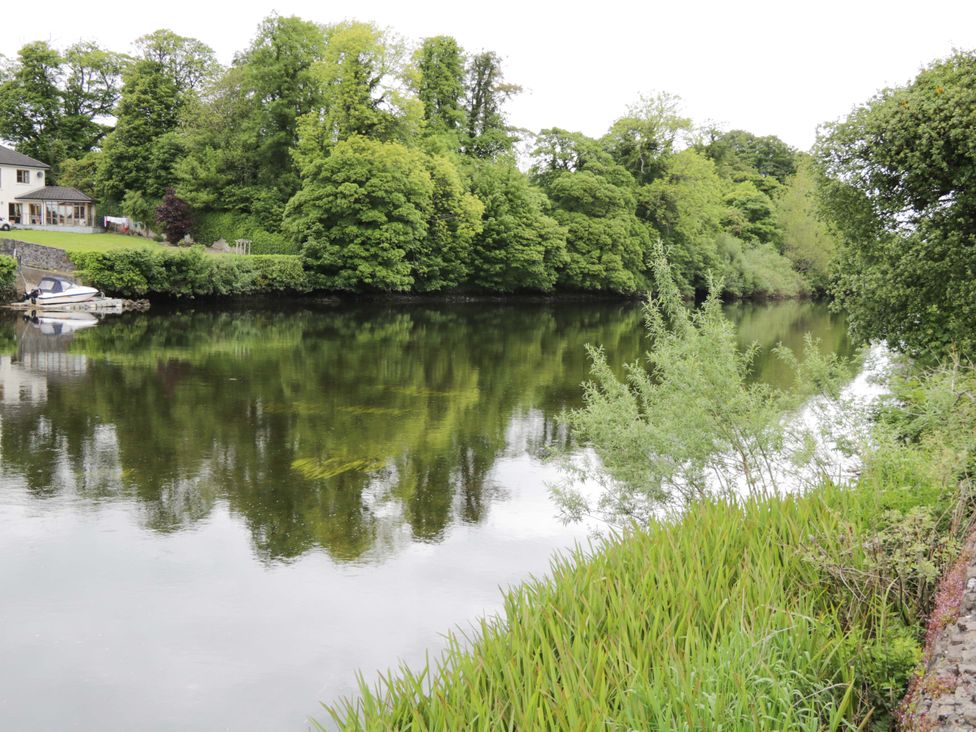 A river with trees and a house by the water at Rose Cottage in Killala, County Mayo