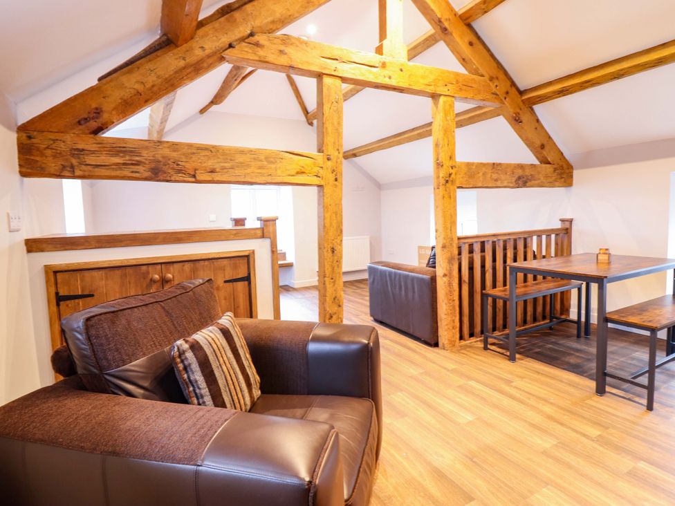 A living room with a sofa and table at Clegir Bach in Corwen