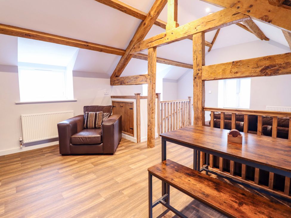 A living room with a chair and table at Clegir Bach in Corwen