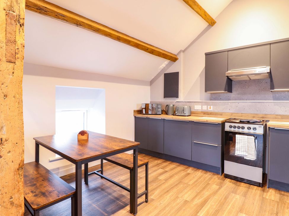 A kitchen with a table and chairs at Clegir Bach in Corwen