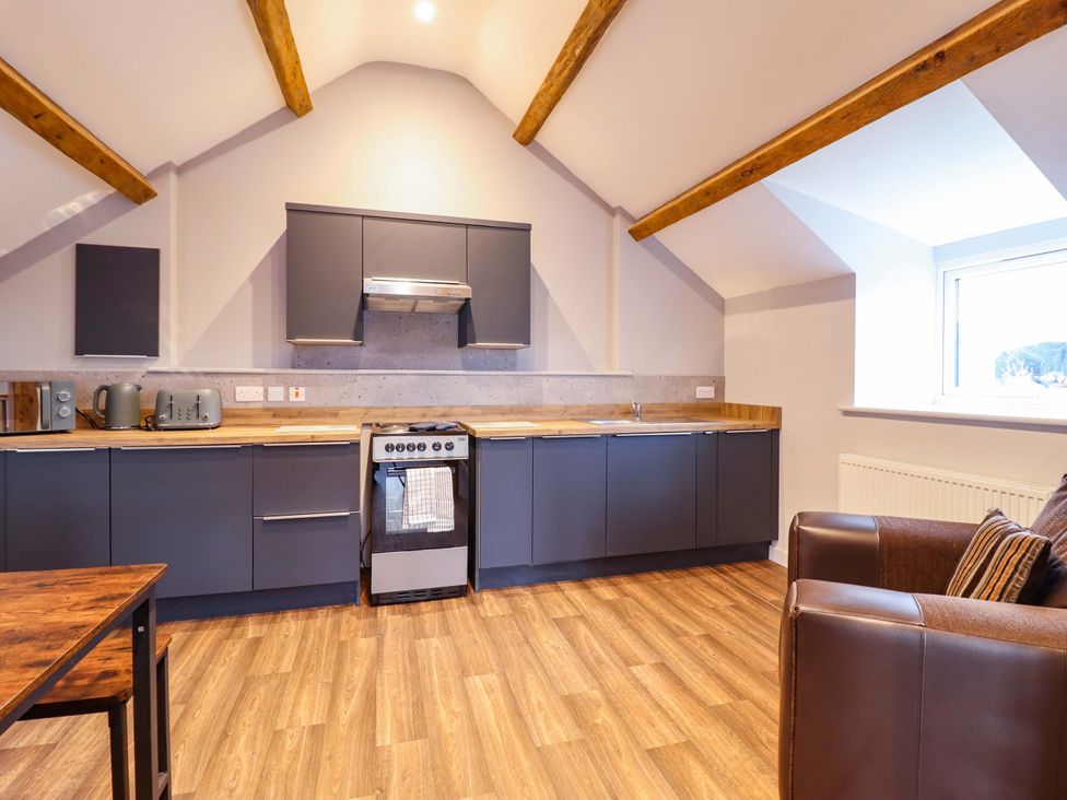 A kitchen with stove and cabinets at Clegir Bach in Corwen
