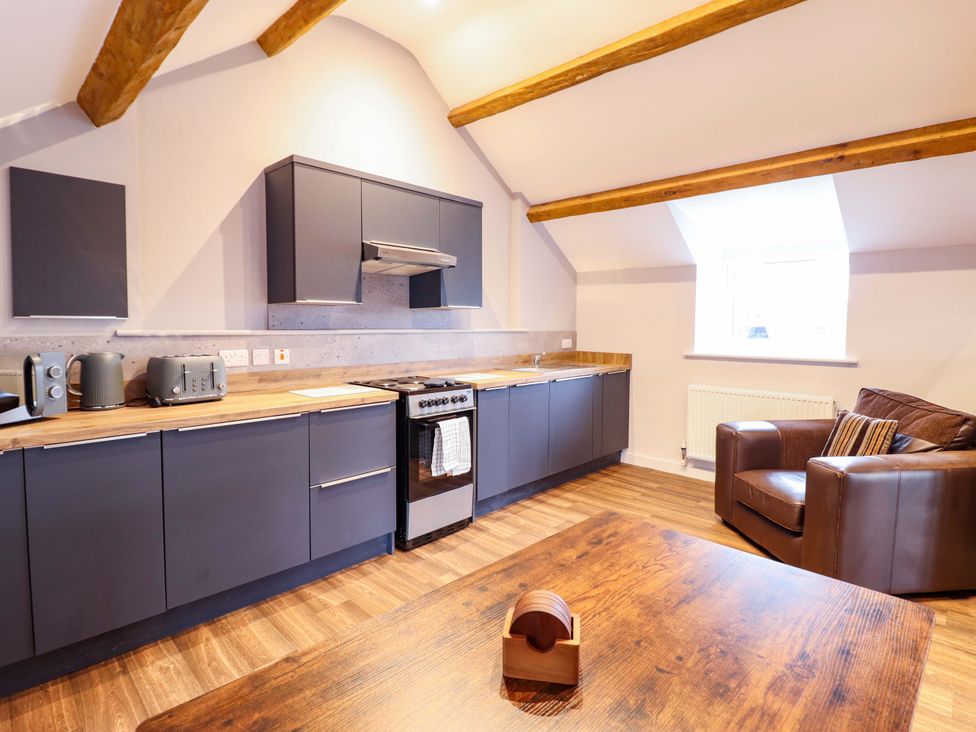 A kitchen with cabinets and appliances at Clegir Bach in Corwen