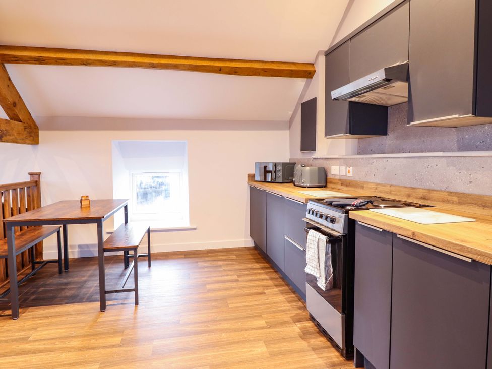 A kitchen with stove and microwave at Clegir Bach in Corwen