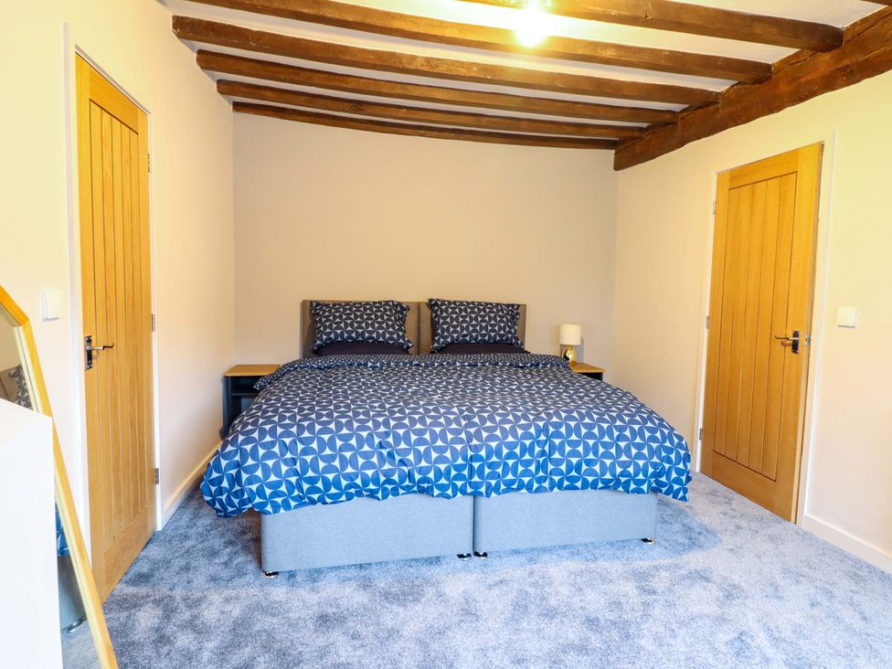 A bedroom with a bed and nightstand at Clegir Bach in Corwen