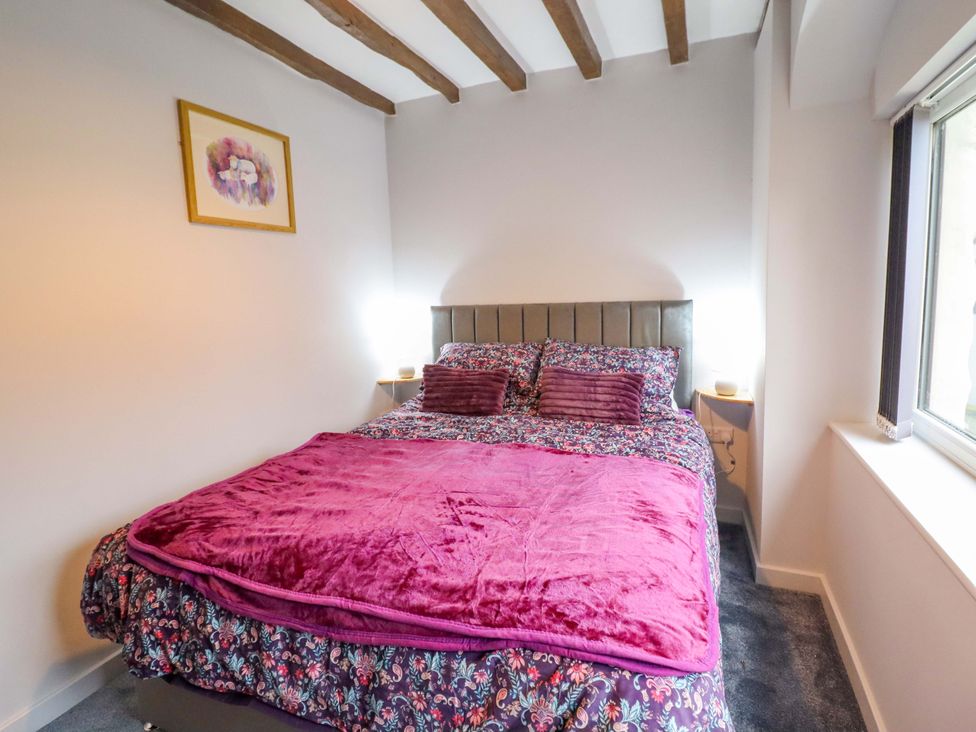 A bedroom with a bed and bedside table at Clegir Bach near Betws Gwerfil Goch