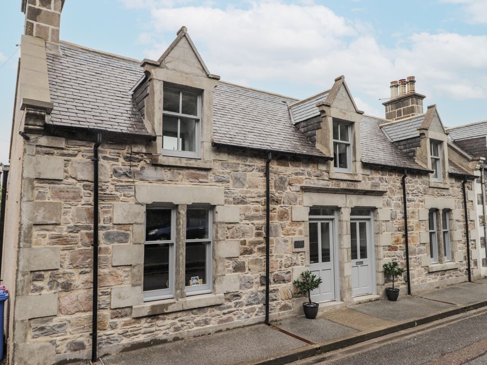 A stone facade with windows and a front door at Apple Tree Cottage in Cullen