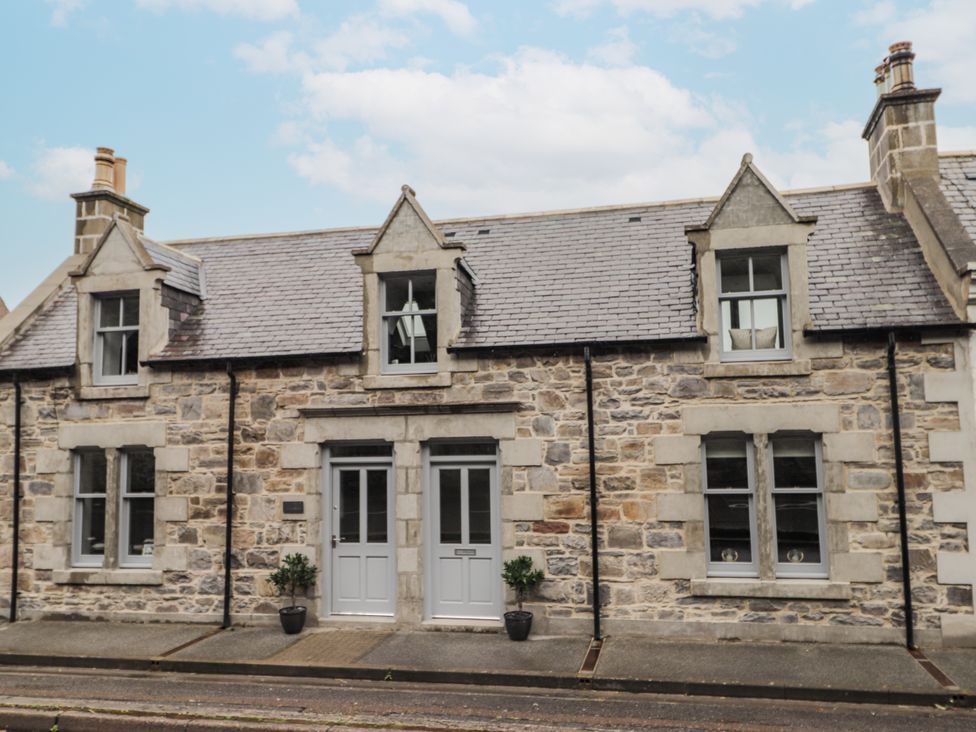 A stone house with gray doors and windows at Apple Tree Cottage in Cullen