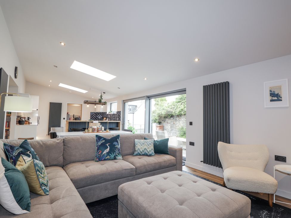 A living room with a sofa and ottoman at Apple Tree Cottage in Cullen