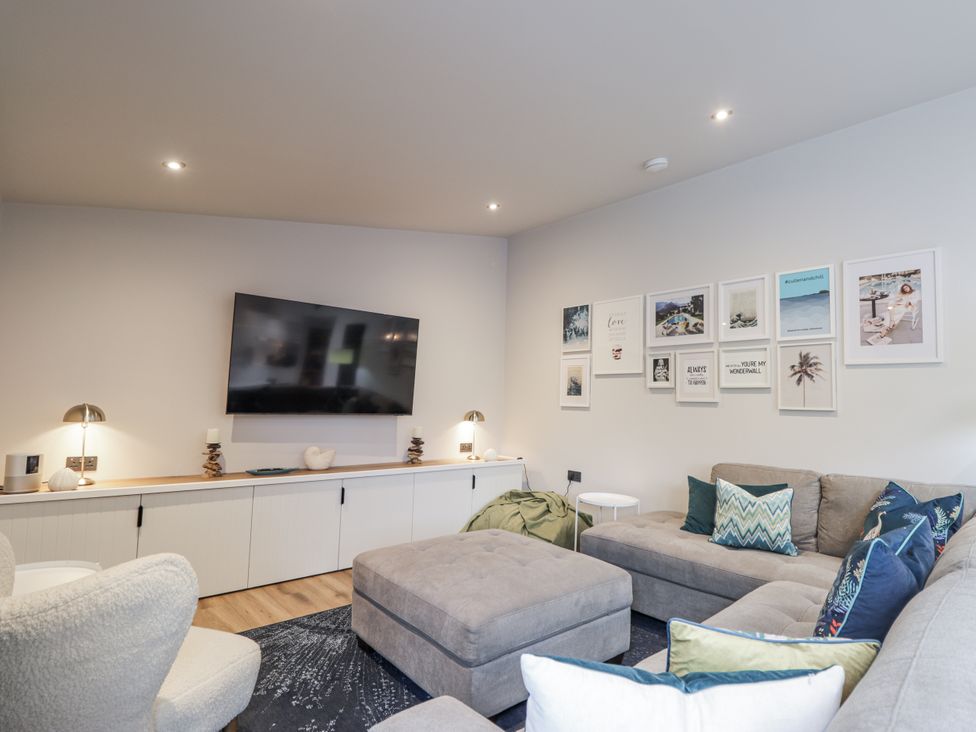 A living room with a television and sofa at Apple Tree Cottage in Cullen