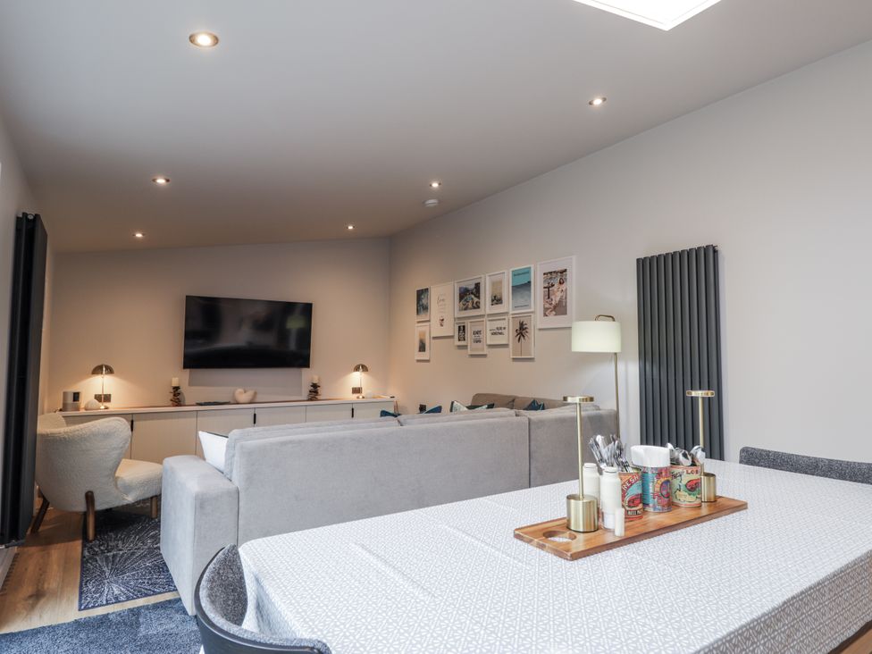 A living room with a television and sofa at Apple Tree Cottage in Cullen