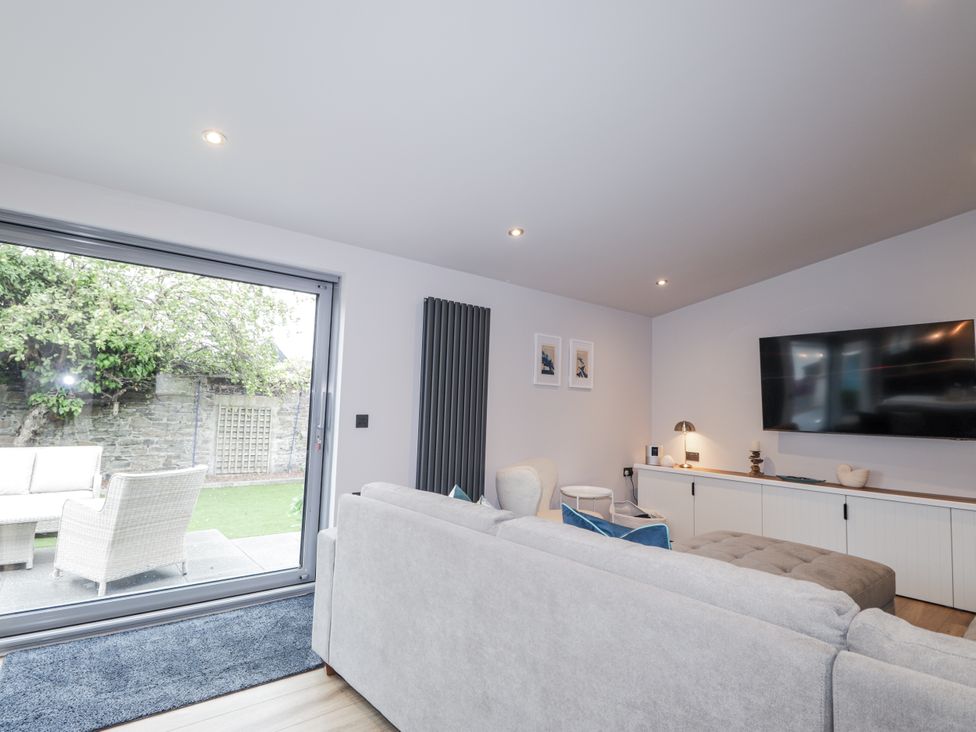 A living room with a television and a sliding door at Apple Tree Cottage in Cullen