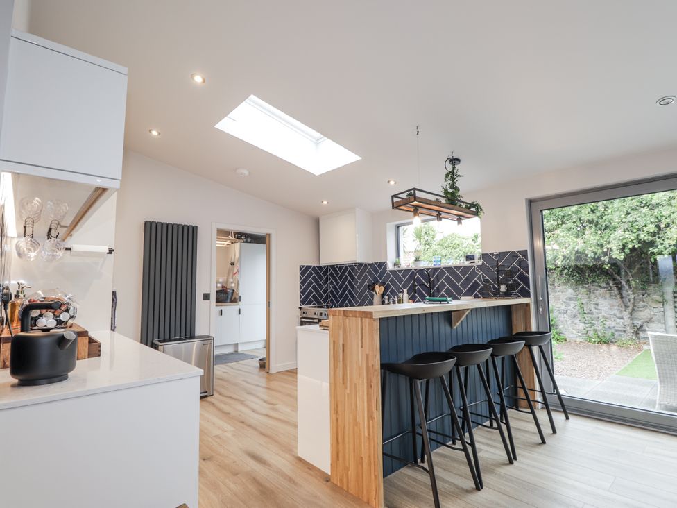 A kitchen with bar stools and a skylight at Apple Tree Cottage in Cullen