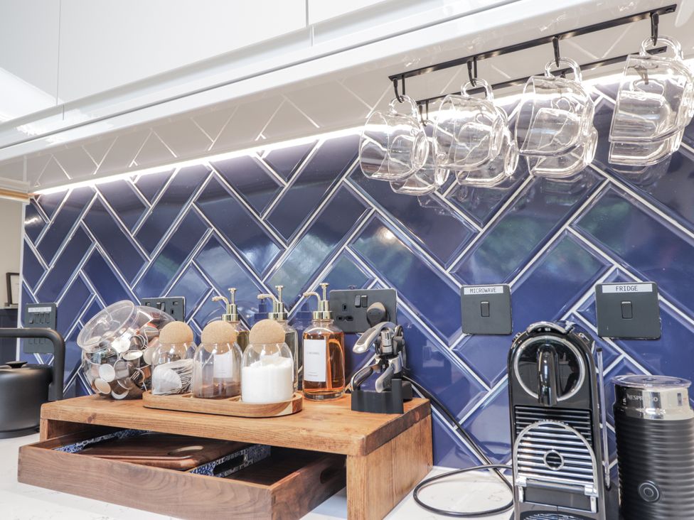 A kitchen with a coffee machine and glass jars at Apple Tree Cottage in Cullen