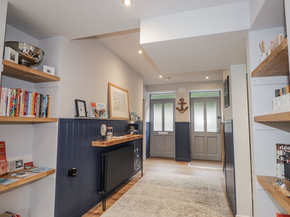 A hallway with shelves and doors at Apple Tree Cottage in Cullen