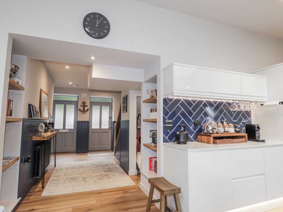 A kitchen with a clock and shelves at Apple Tree Cottage in Cullen