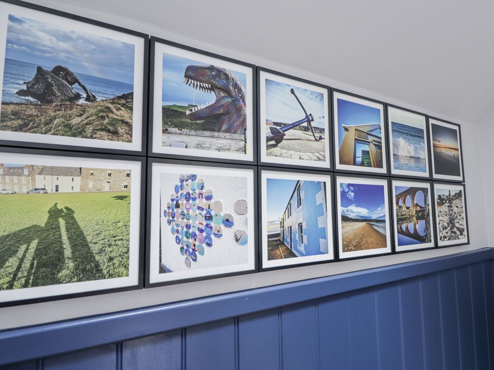 A wall with framed photographs at Apple Tree Cottage in Cullen