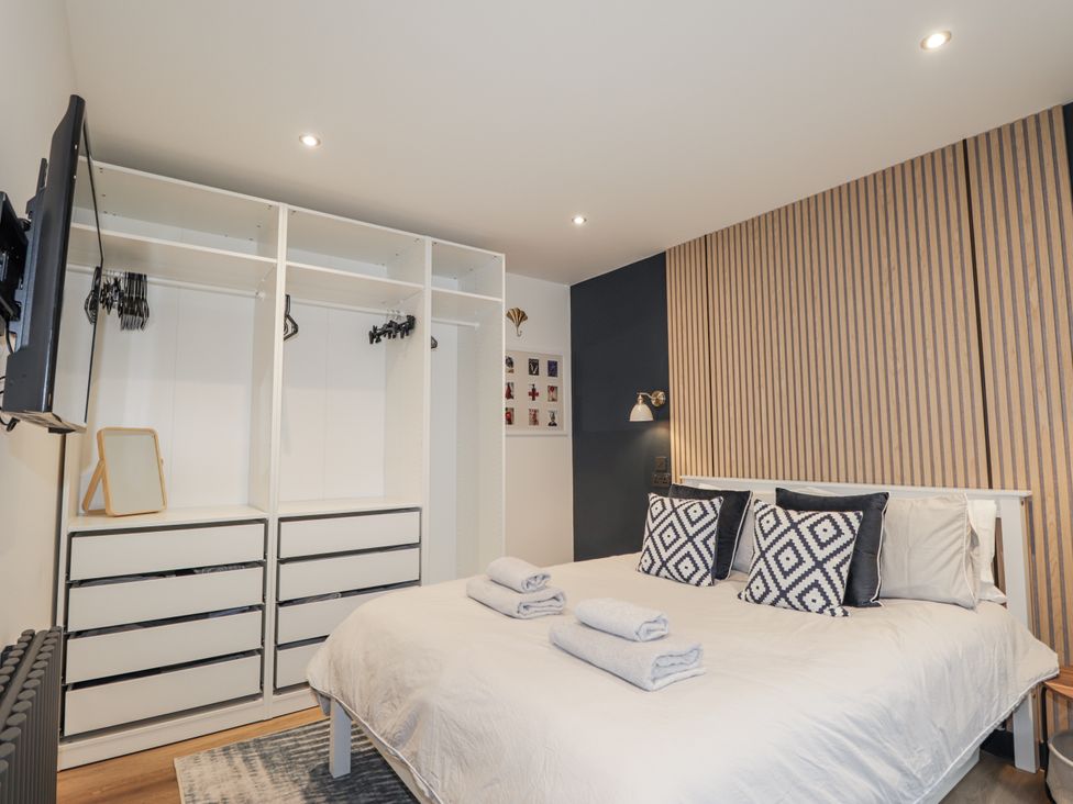 A bedroom with a bed and wardrobe at Apple Tree Cottage in Cullen