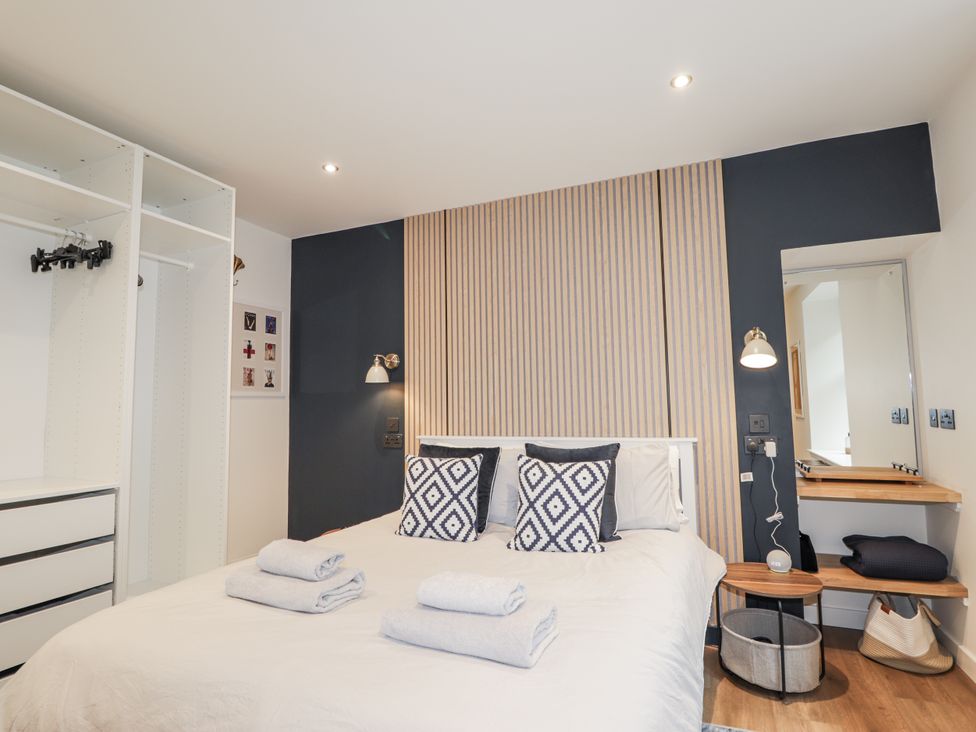 A bedroom with a bed and dresser at Apple Tree Cottage in Cullen