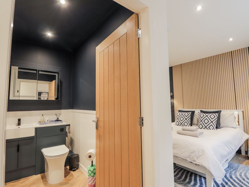 A bathroom connected to a bedroom featuring a toilet and sink at Apple Tree Cottage in Cullen