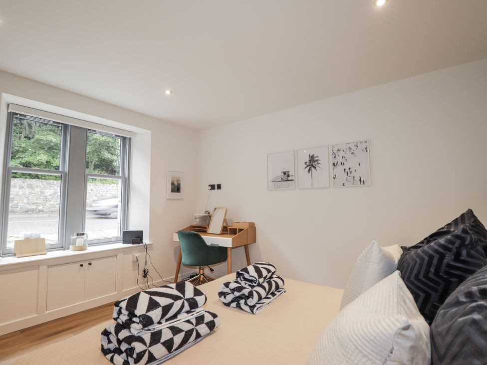 A bedroom with towels on bed and desk at Apple Tree Cottage in Cullen
