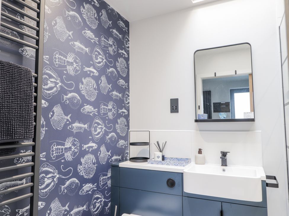 A bathroom with sink and mirror at Apple Tree Cottage in Cullen
