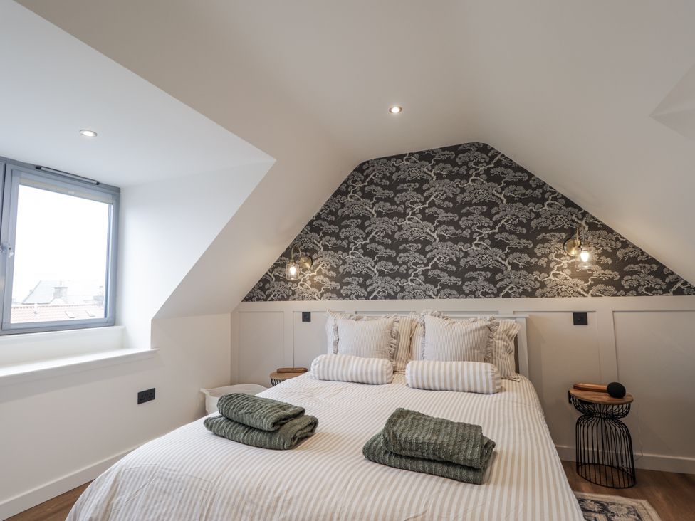 A bedroom with a bed and window at Apple Tree Cottage in Cullen
