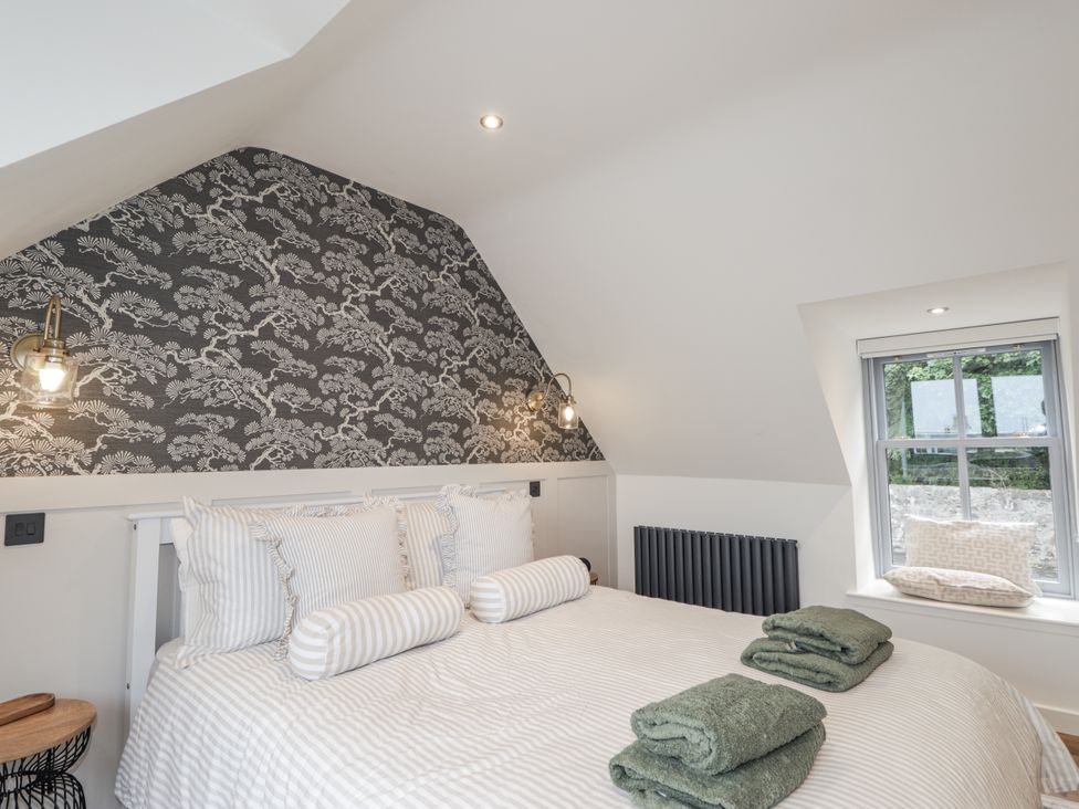 A bedroom with a bed and window at Apple Tree Cottage in Cullen