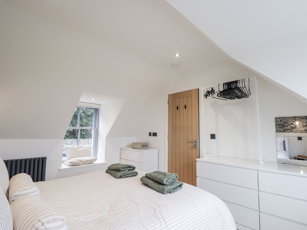 A bedroom with a bed and dresser at Apple Tree Cottage in Cullen