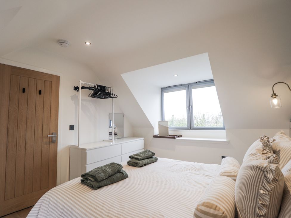 A bedroom with a bed and window at Apple Tree Cottage in Cullen