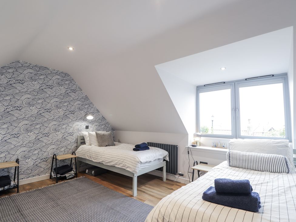 A bedroom with two beds and a window at Apple Tree Cottage in Cullen
