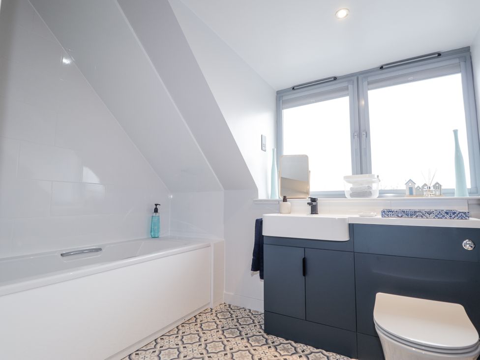 A bathroom with a bathtub, sink, and toilet at Apple Tree Cottage in Cullen