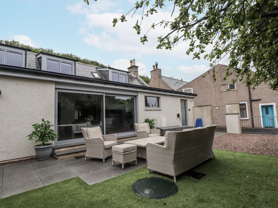 A garden with seating area and plants at Apple Tree Cottage Cullen