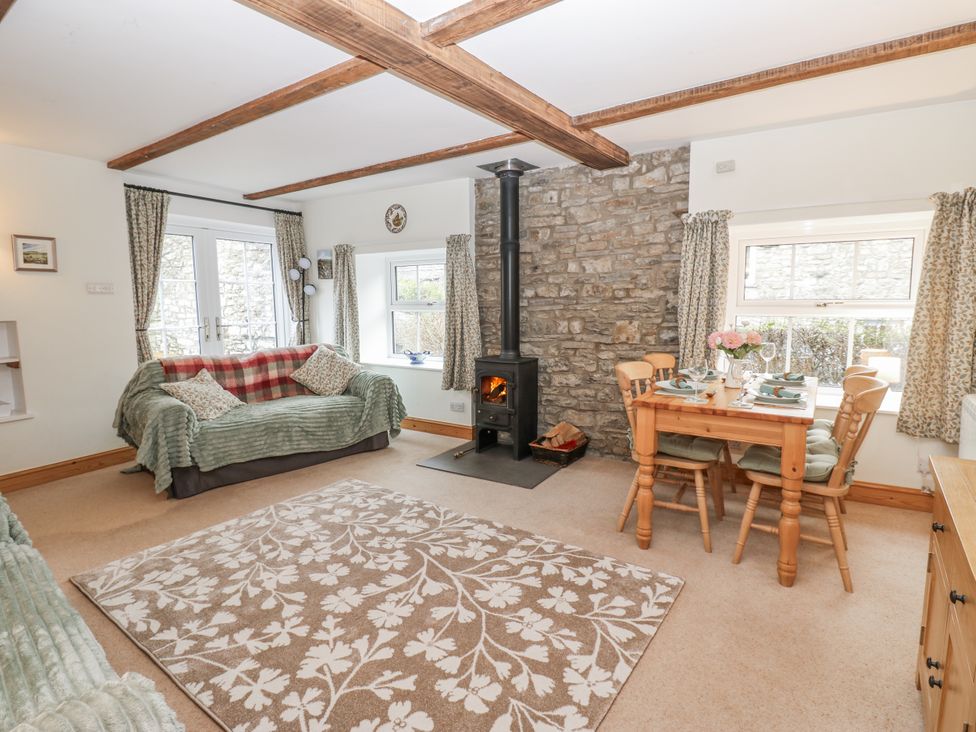 A living room with a sofa and wooden table at 1 Mill Cottage (known as Old Mill 1) Askrigg near West Burton