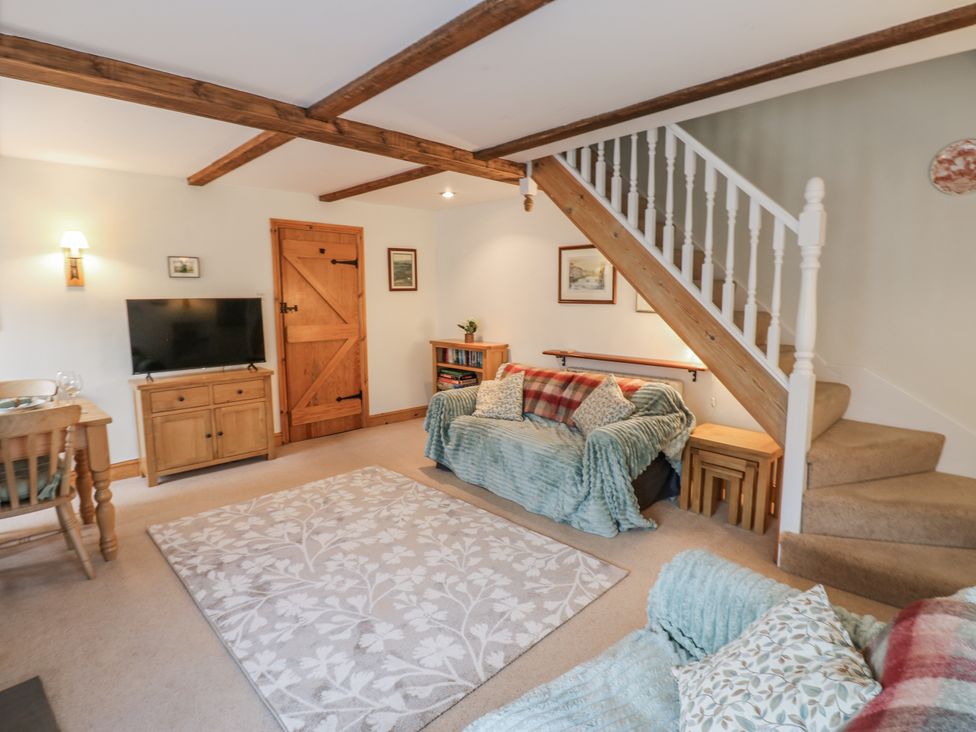 A living room with a sofa and tv at 1 Mill Cottage known as Old Mill 1 Askrigg near West Burton