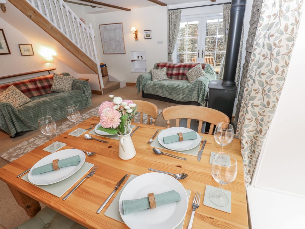 A living room with a dining table set and a sofa at 1 Mill Cottage (known as Old Mill 1) Askrigg near West Burton