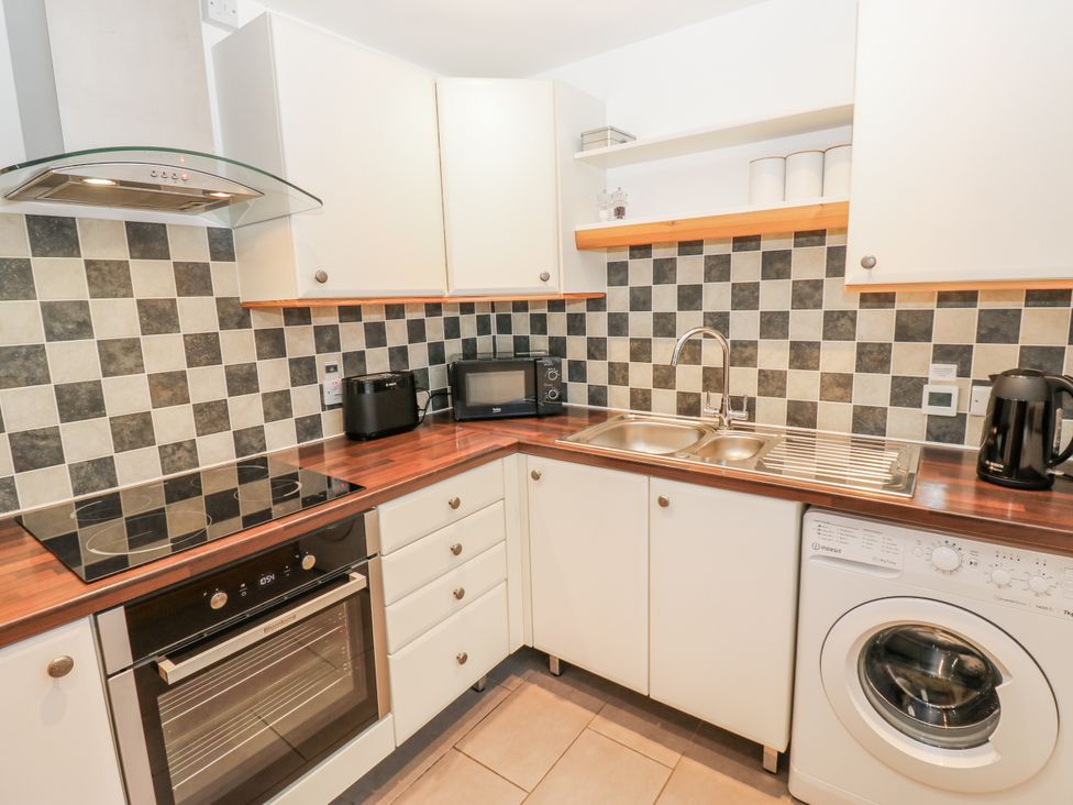 A kitchen with stove, oven, sink, and microwave at 1 Mill Cottage (known as Old Mill 1) Askrigg near West Burton