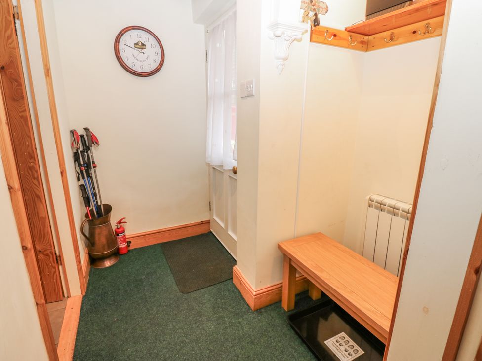 A hallway with a clock and ski poles at 1 Mill Cottage (known as Old Mill 1) Askrigg near West Burton