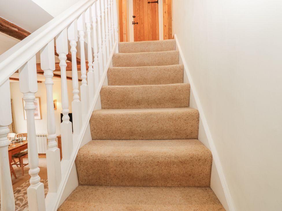 A staircase with carpet and a wooden door at 1 Mill Cottage (known as Old Mill 1) Askrigg near West Burton